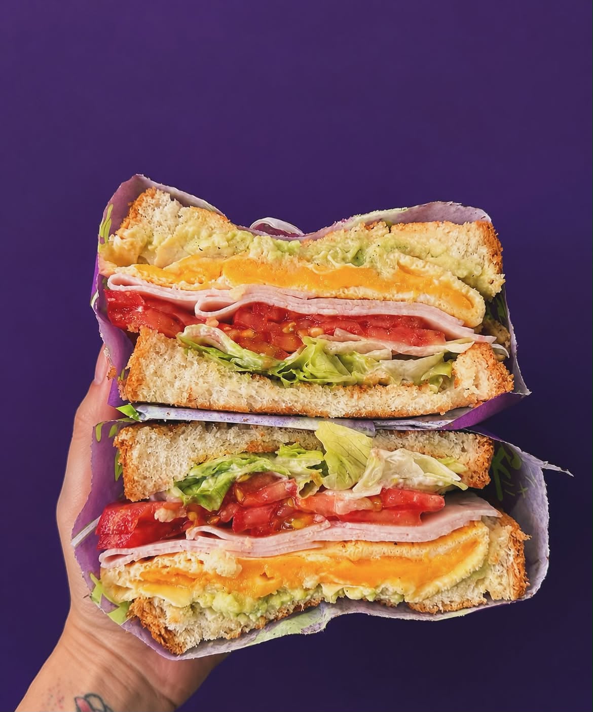Club sando held open against a deep purple backdrop