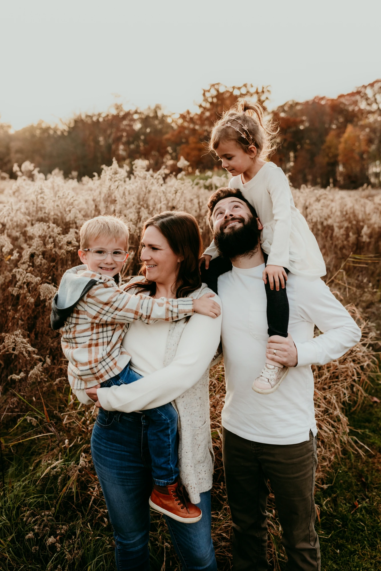 Kelsey — pediatric occupational therapist and founder of Growing Balanced — outdoors with her family in a golden autumn field