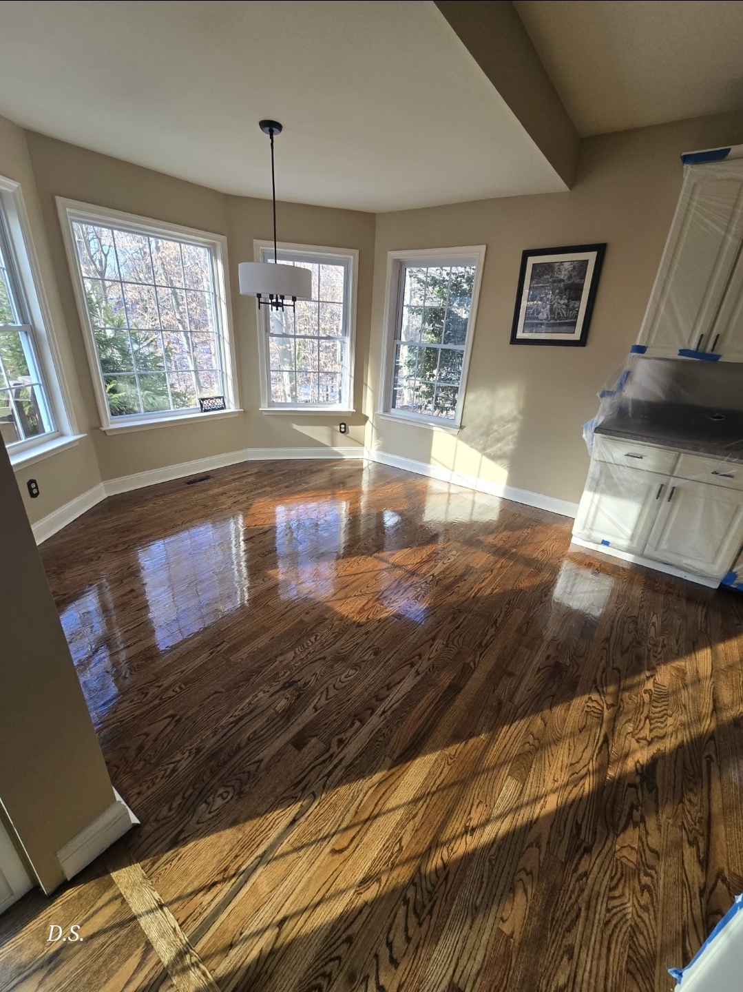 Refinished hardwood floor beside a stone fireplace in Pennsylvania