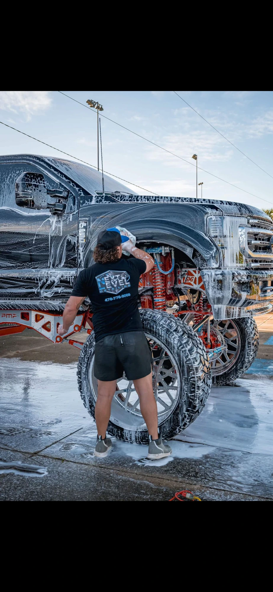 Hand wash on a lifted truck during a mobile detail